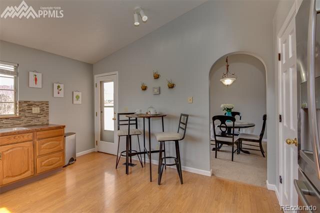 6150 Rabbit Ears Court Colorado Springs, CO 80919 - Photo 10 of 31 a view of a dining room with furniture and wooden floor