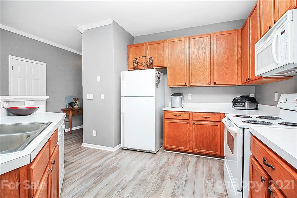 911 Azurine Circle, Unit 74 Fort Mill, SC 29708 - Photo 13 of 40 a kitchen with stainless steel appliances granite countertop a refrigerator a sink dishwasher and wooden cabinets with wooden floor