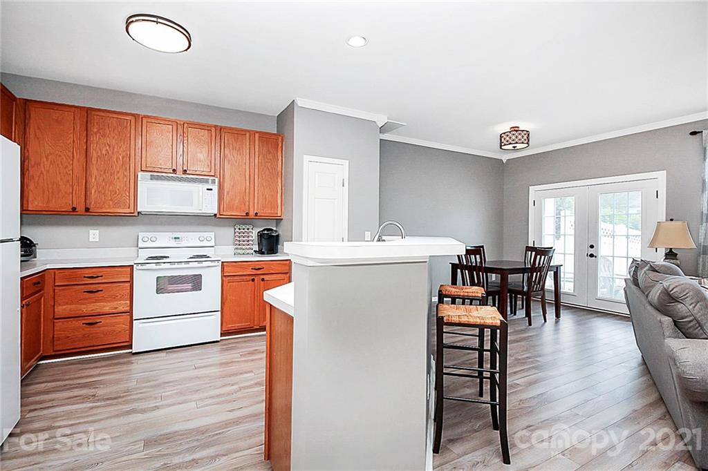 911 Azurine Circle, Unit 74 Fort Mill, SC 29708 - Photo 10 of 40 a kitchen with stainless steel appliances granite countertop a stove top oven a sink a dining table and chairs with wooden floor