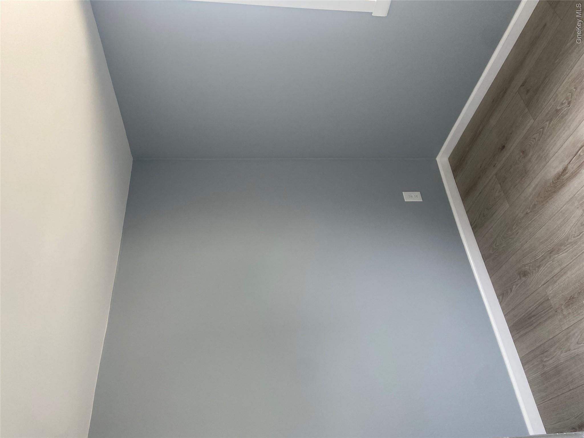 85-15 85th Street, Unit 2 Queens, NY 11421 - Photo 8 of 22 Light gray walls with white trim and wood-finish flooring