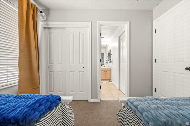 174 Rockey Park Lane, Unit 34 Draper, UT 84020 - Photo 15 of 20 Bedroom with a textured ceiling, light colored carpet, and a closet