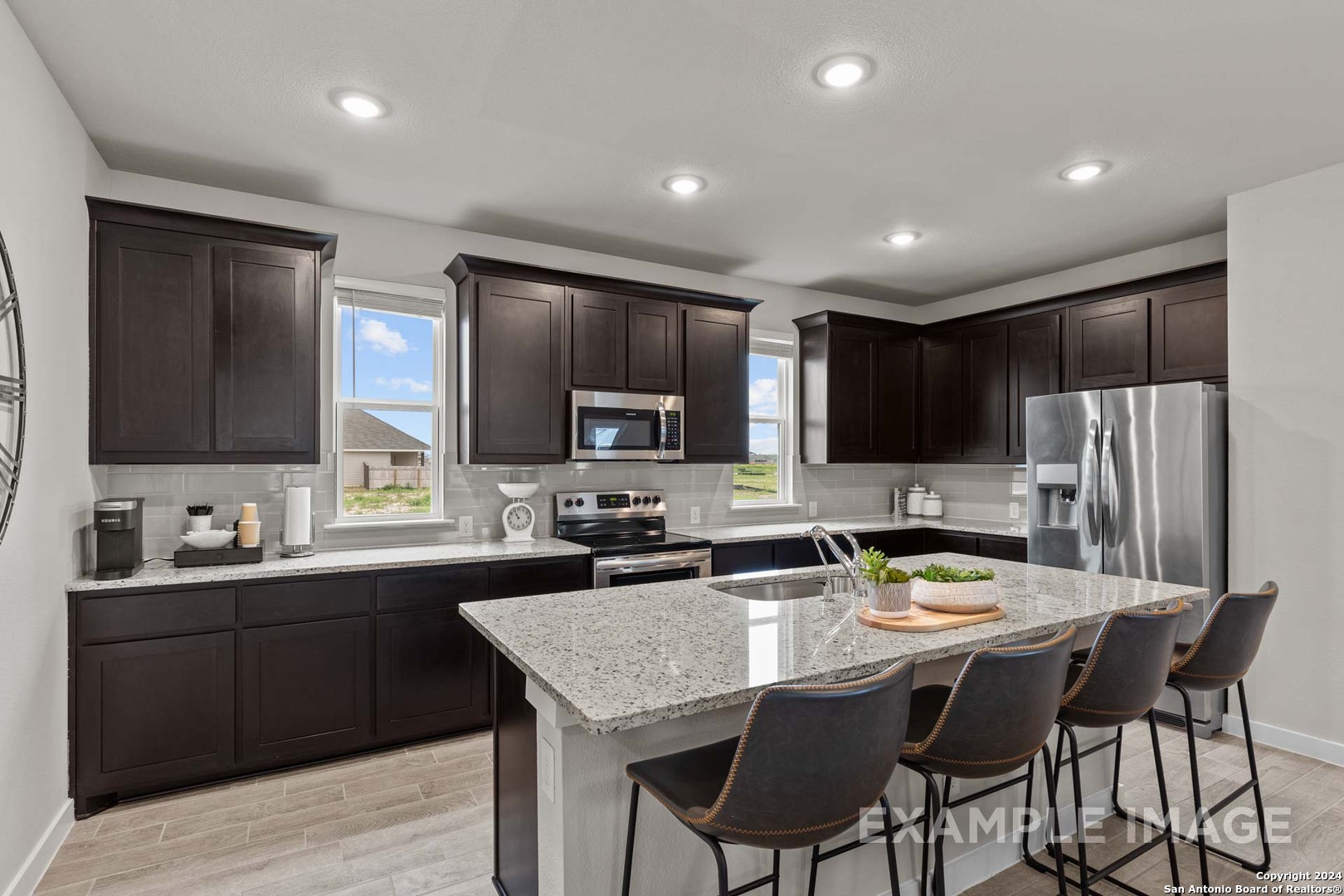 401 Tims Way Seguin, TX 78155 - Photo 23 of 50 a kitchen with stainless steel appliances granite countertop a sink dishwasher a stove a refrigerator with a dining table and chairs