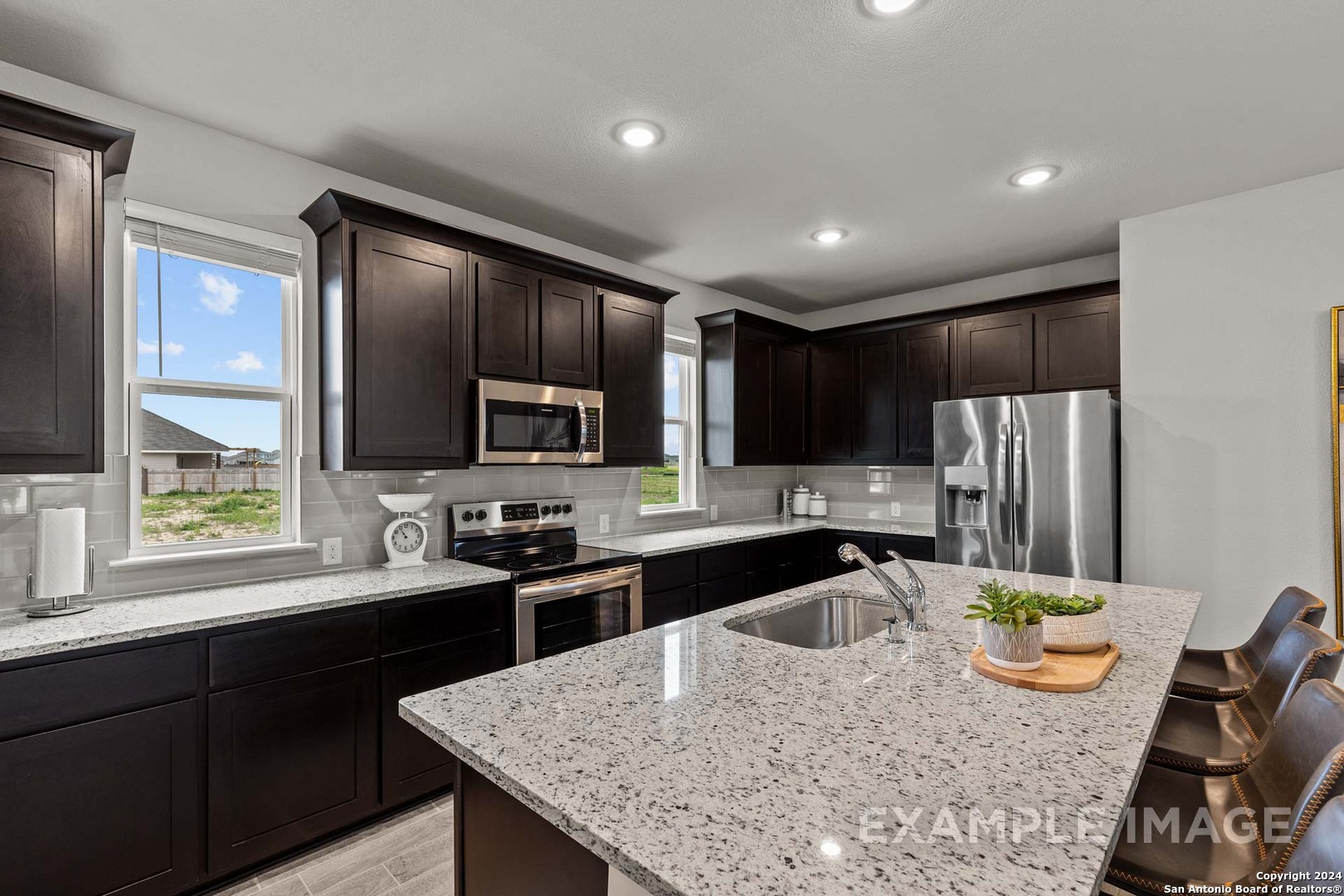 401 Tims Way Seguin, TX 78155 - Photo 24 of 50 a kitchen with stainless steel appliances granite countertop sink stove refrigerator and cabinets