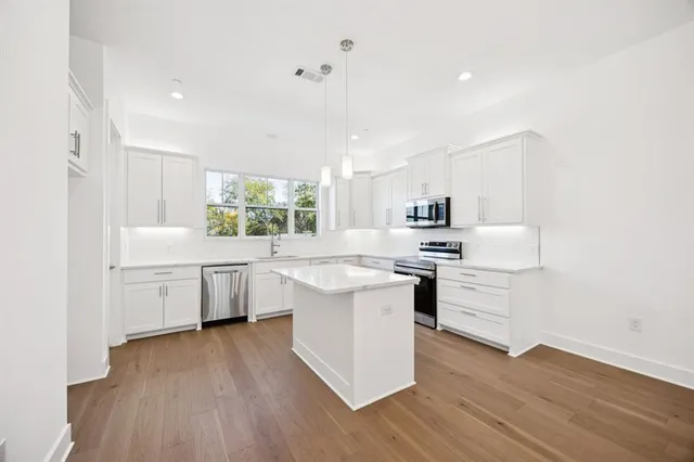 a kitchen with cabinets wooden floor and a sink