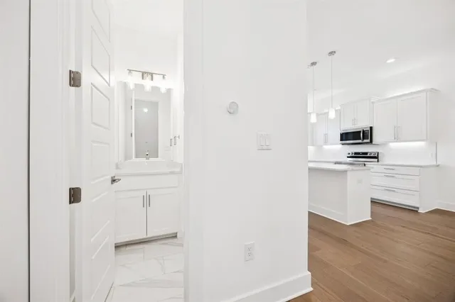 a kitchen with cabinets and wooden floor