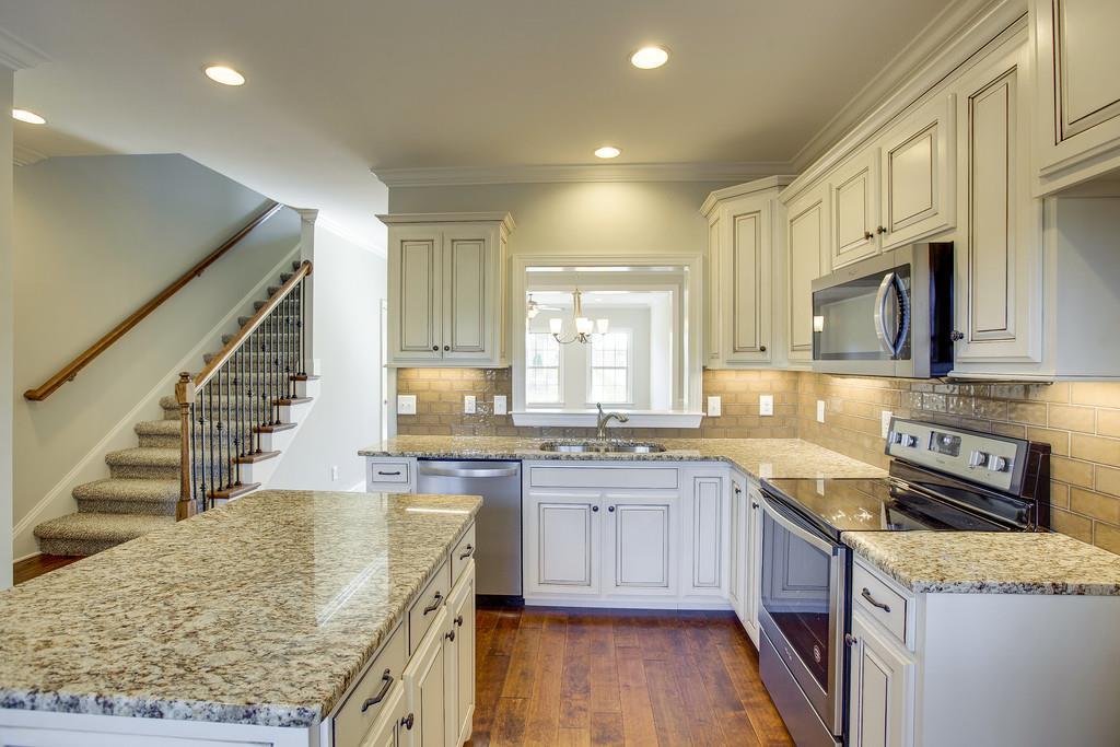 4325 Glassgow Road Spring Hill, TN 37174 - Photo 1 of 28 a kitchen with stainless steel appliances granite countertop a sink stove and cabinets