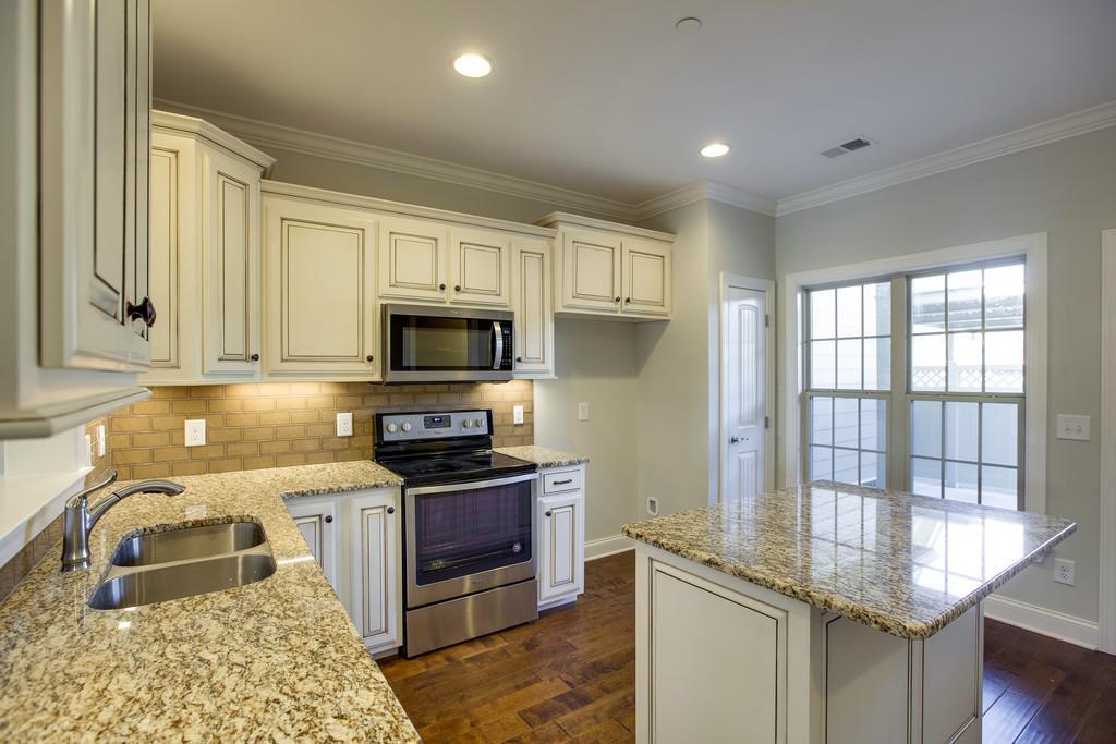 4325 Glassgow Road Spring Hill, TN 37174 - Photo 10 of 28 a kitchen with stainless steel appliances granite countertop a sink stove and cabinets