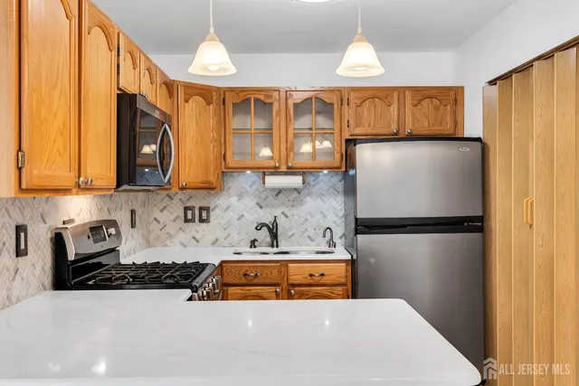 a kitchen with stainless steel appliances a refrigerator and a stove