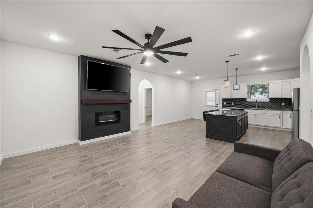 6771 Northwest County Road 1146 Barry, TX 75102 - Photo 6 of 34 a living room with furniture a fireplace and a flat screen tv