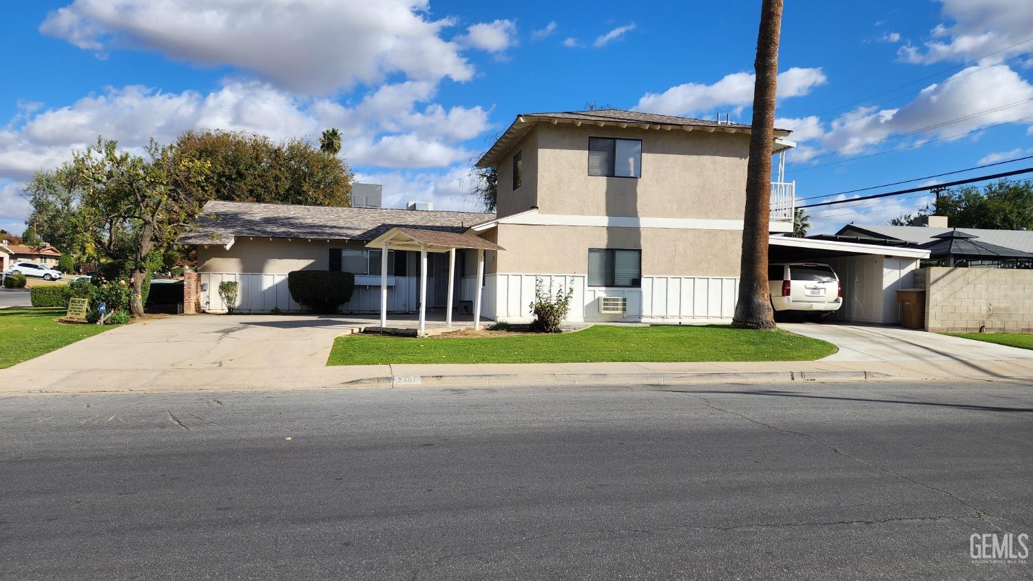 Undisclosed Address Bakersfield, CA 93306 - Photo 2 of 20 a view of a white house with a yard next to a road