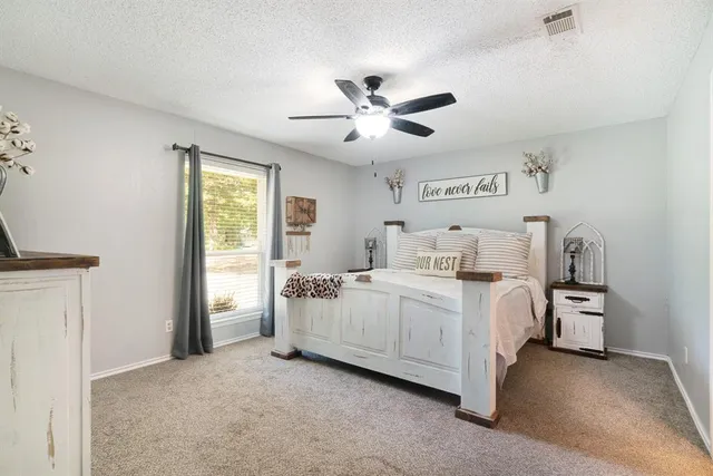 a room with white bed and a ceiling fan
