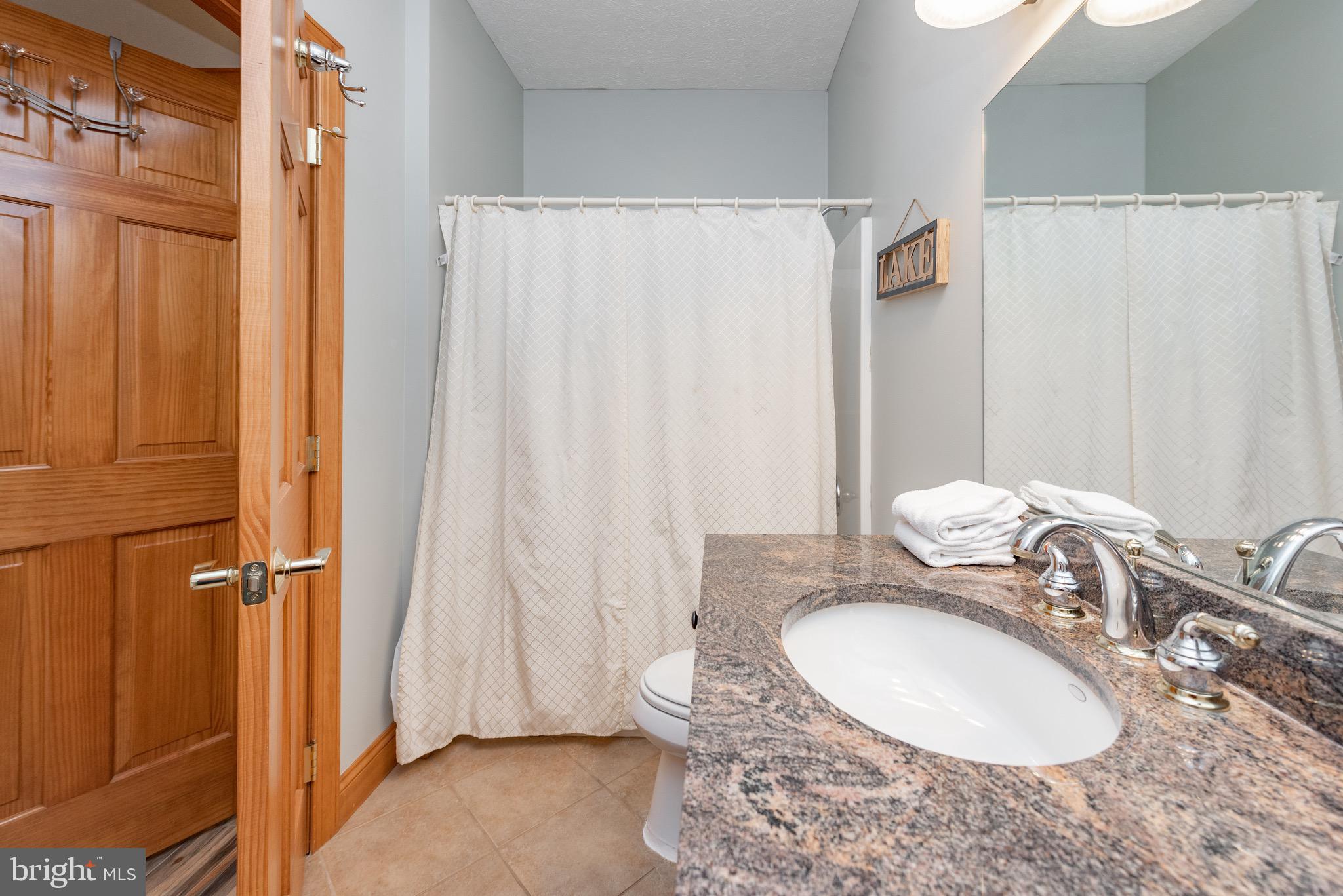 38 Parkside Court North McHenry, MD 21541 - Photo 33 of 60 a bathroom with a granite countertop sink and a mirror