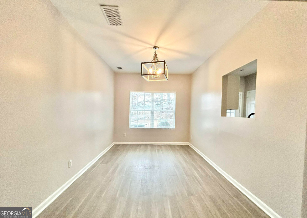 1017 Wheel House Lane, Unit A Monroe, GA 30655 - Photo 4 of 9 a view of hallway with window and wooden floor