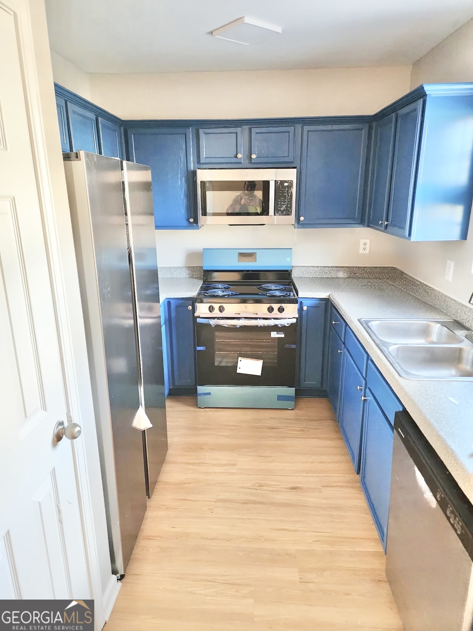 1017 Wheel House Lane, Unit A Monroe, GA 30655 - Photo 5 of 9 a kitchen with wooden cabinets and refrigerator