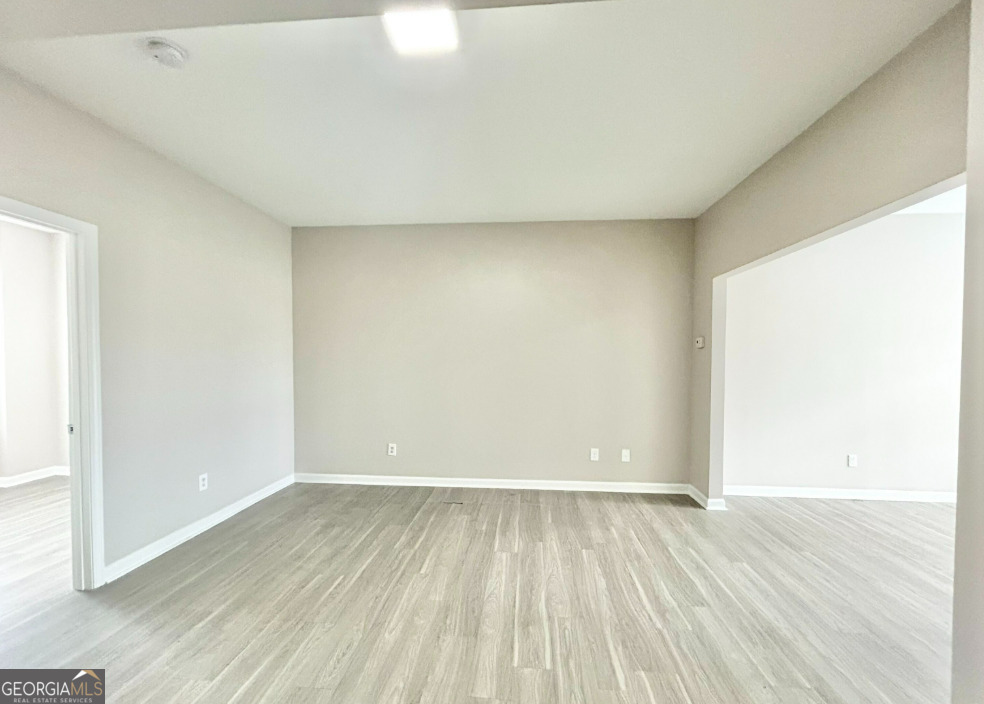 1017 Wheel House Lane, Unit A Monroe, GA 30655 - Photo 7 of 9 an empty room with wooden floor