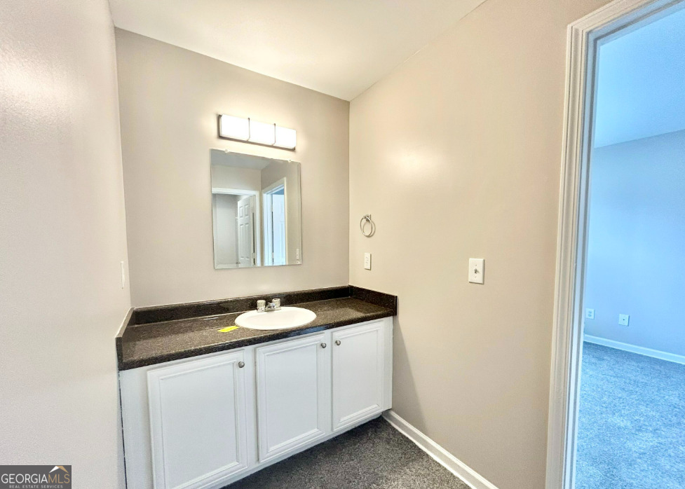 1017 Wheel House Lane, Unit A Monroe, GA 30655 - Photo 9 of 9 a bathroom with a granite countertop sink and a mirror