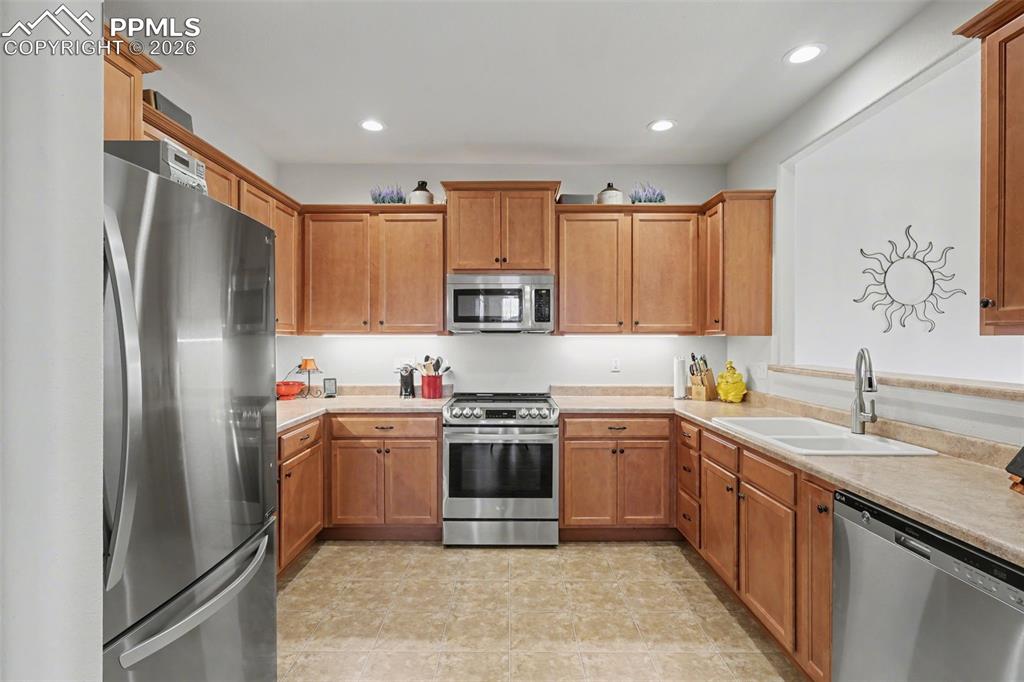 17063 Blue Mist Grove Monument, CO 80132 - Photo 7 of 33 a kitchen with stainless steel appliances granite countertop a refrigerator sink and stove