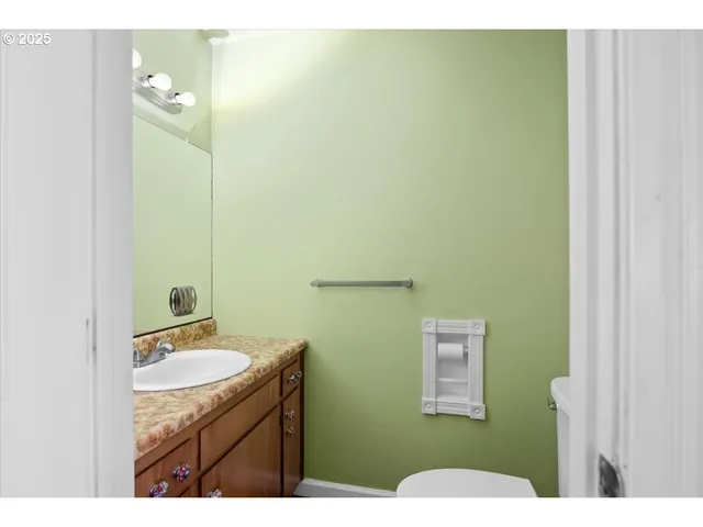 a bathroom with a granite countertop sink toilet and mirror