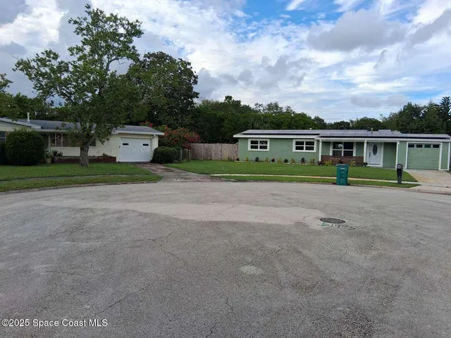 a view of a backyard with table and chairs and a barn with large windows