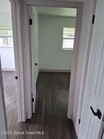 a view of a hallway with wooden floor