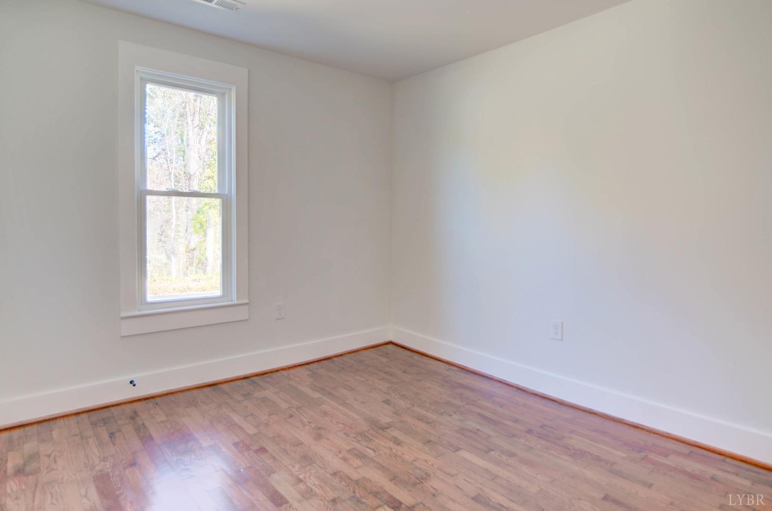 234 Baileys Sawmill Road Amherst, VA 24521 - Photo 12 of 32 an empty room with wooden floor and windows