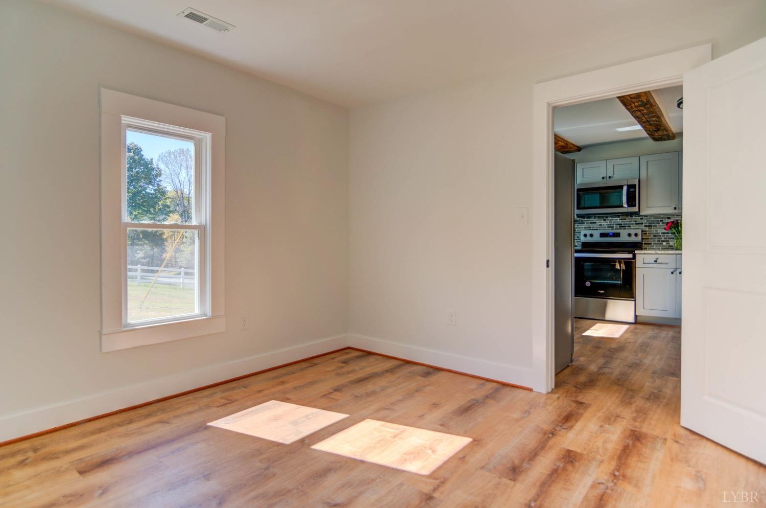 234 Baileys Sawmill Road Amherst, VA 24521 - Photo 20 of 32 an empty room with wooden floor cabinet and windows