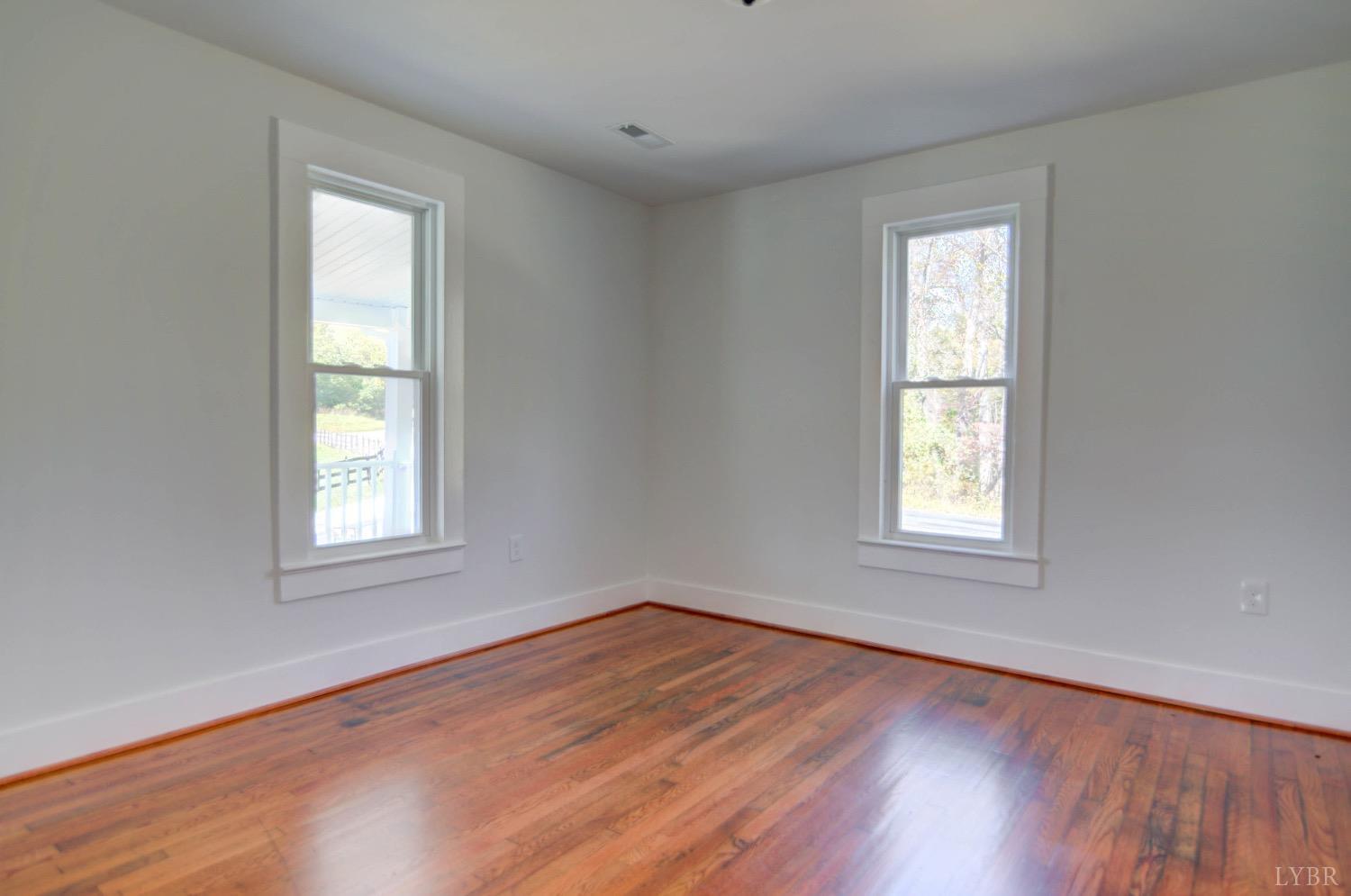 234 Baileys Sawmill Road Amherst, VA 24521 - Photo 9 of 32 an empty room with wooden floor and windows