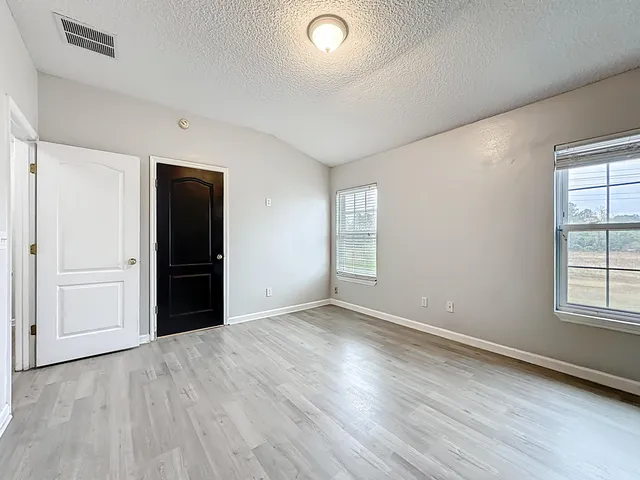an empty room with windows and closet