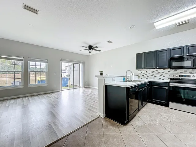 a large kitchen with stainless steel appliances granite countertop a refrigerator and a stove