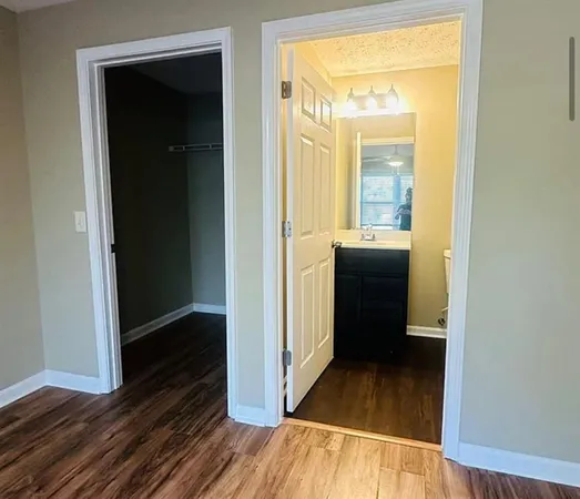 a view of a hallway with wooden floor and closet