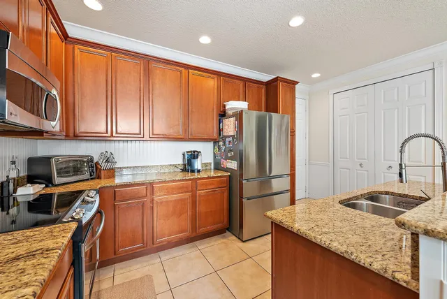 a kitchen with stainless steel appliances granite countertop a refrigerator sink and stove