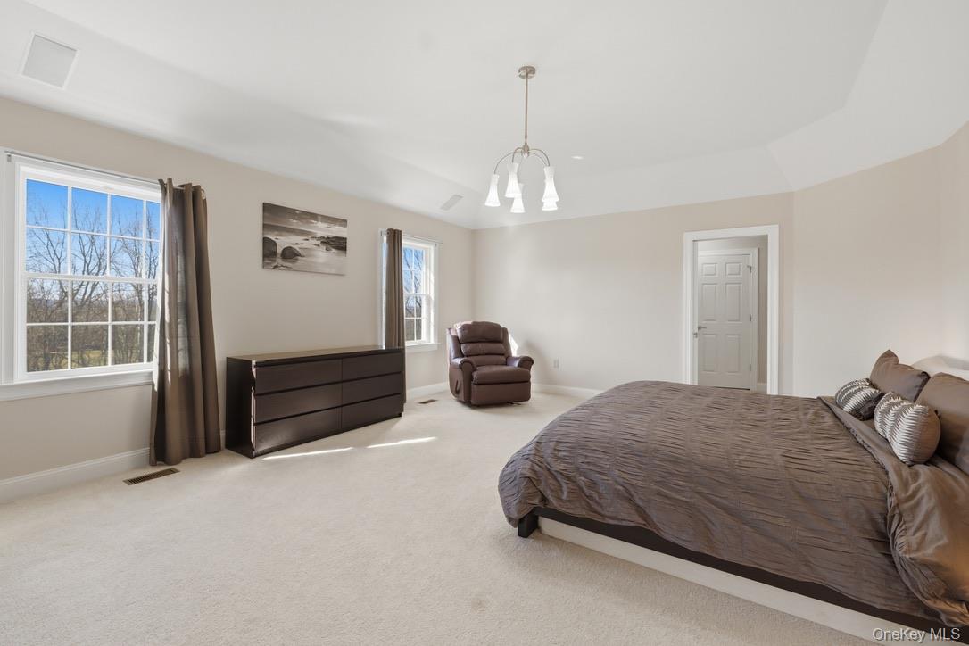 12 Feagles Road Warwick, NY 10990 - Photo 29 of 45 a bedroom with a bed and a chandelier