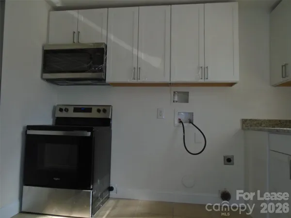 a view of a microwave and cabinets