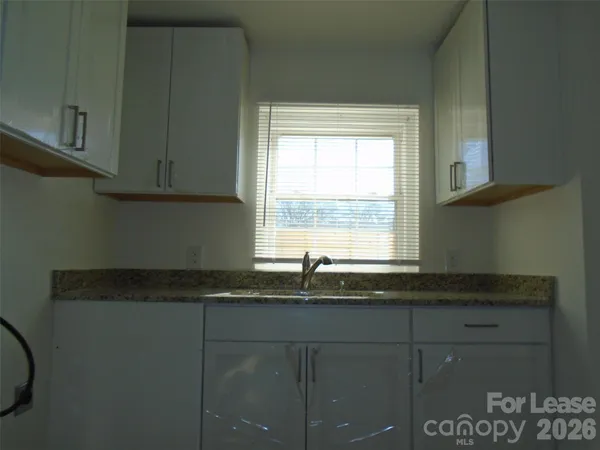 a kitchen with granite countertop a sink and a window