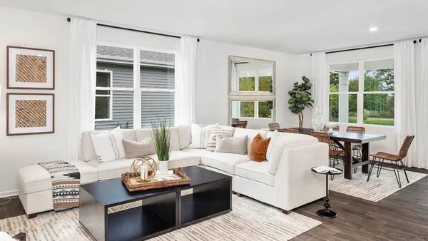 a living room with furniture and large windows
