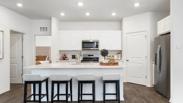a kitchen with a table chairs refrigerator and microwave