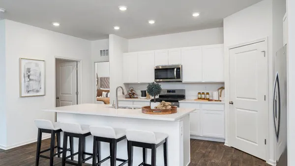 a kitchen with a dining table chairs refrigerator and cabinets