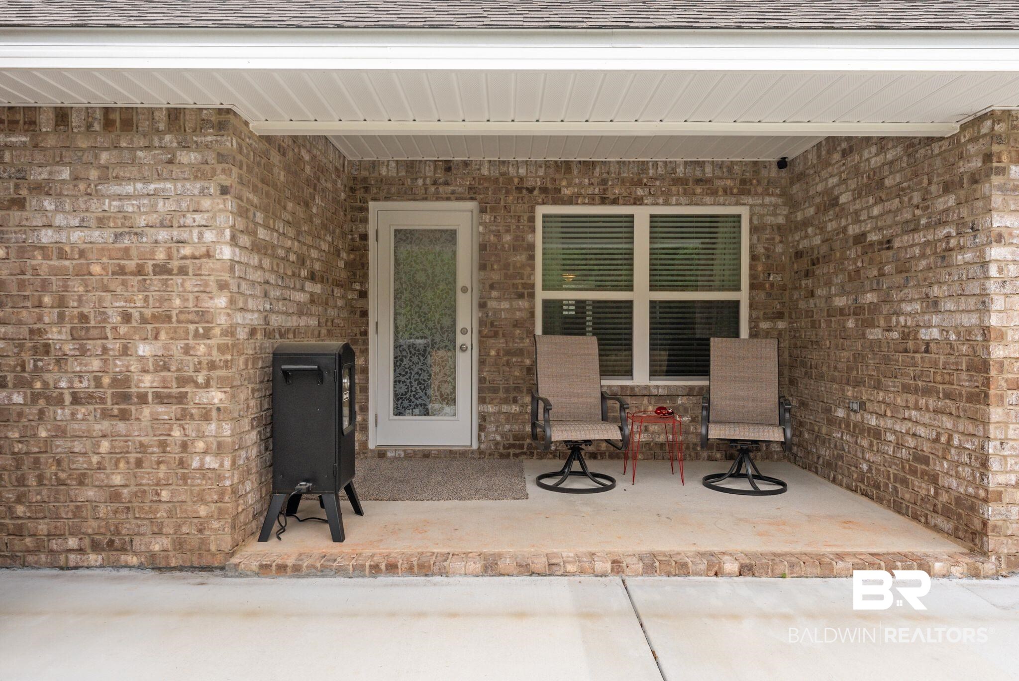 692 Mayflower Drive Foley, AL 36535 - Photo 34 of 40 Doorway to property with brick siding, roof with shingles, and a patio