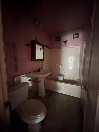 a bathroom with a toilet sink and mirror