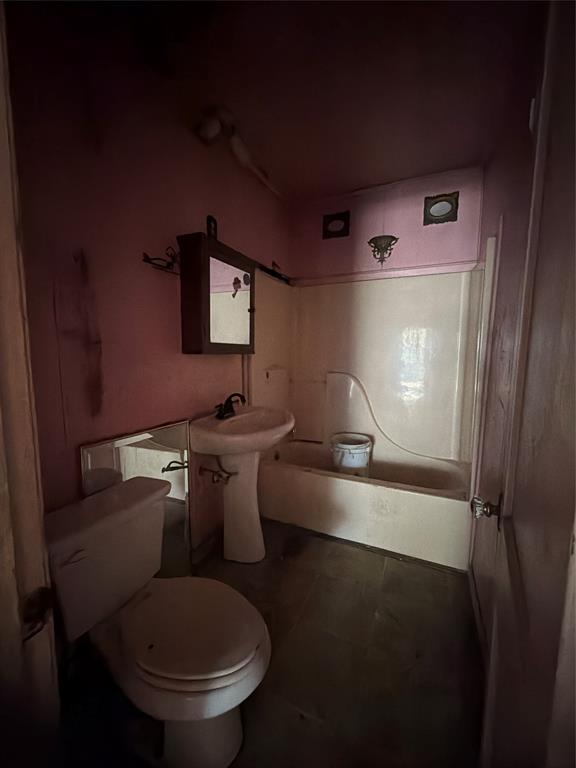 205 Graham Avenue Bonham, TX 75418 - Photo 5 of 8 a bathroom with a toilet sink and mirror