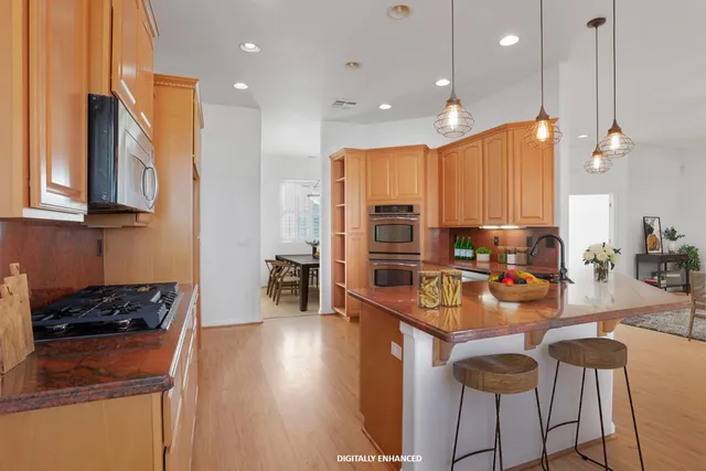 a kitchen with stainless steel appliances granite countertop a sink a stove and a refrigerator