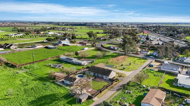an aerial view of a swimming pool with lawn chairs and large trees