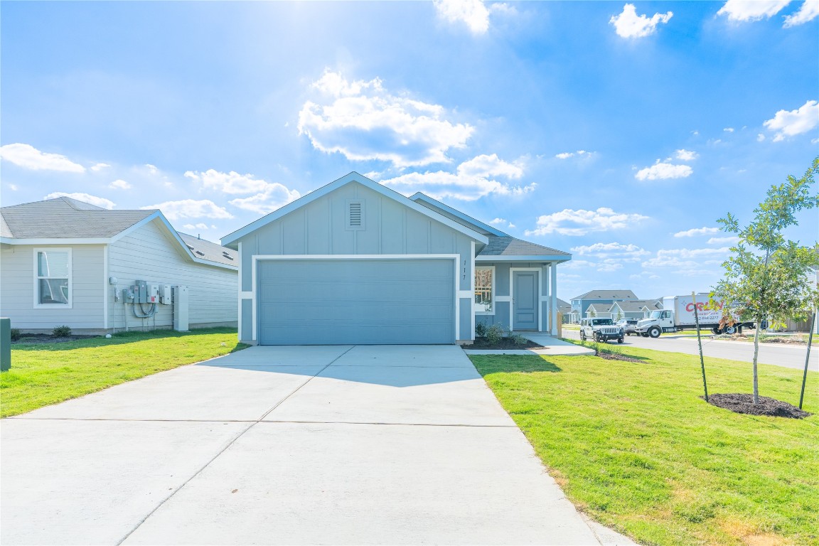 117 Dark Victory Road Jarrell, TX 76537 - Photo 1 of 1 Ranch-style home featuring board and batten siding, a front lawn, concrete driveway, and an attached garage