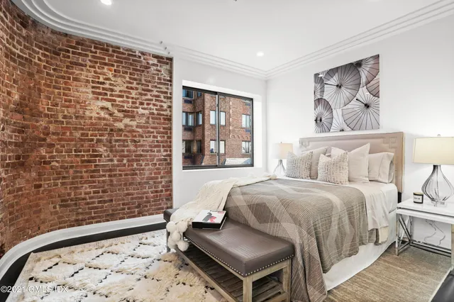 a bedroom with a bed and a painting on the wall