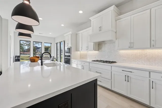 a kitchen with white cabinets appliances and a center island