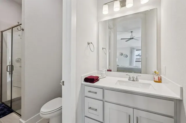 a bathroom with a sink toilet vanity and shower