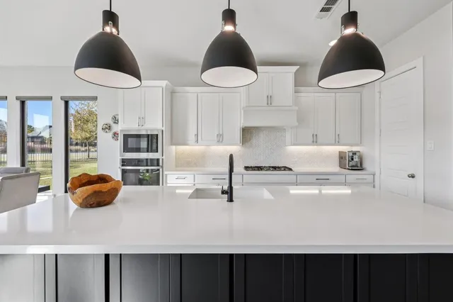a kitchen with stainless steel appliances a table and chairs