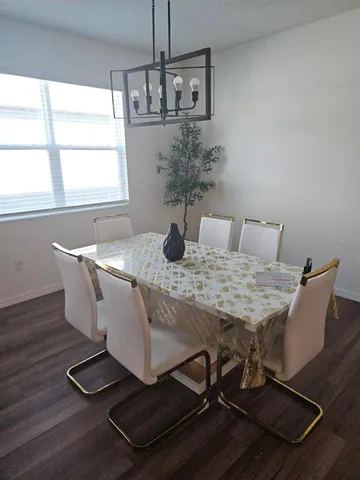 a dining room with table chairs and wooden floor