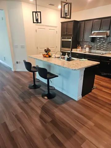 a room with table chairs and wooden floor