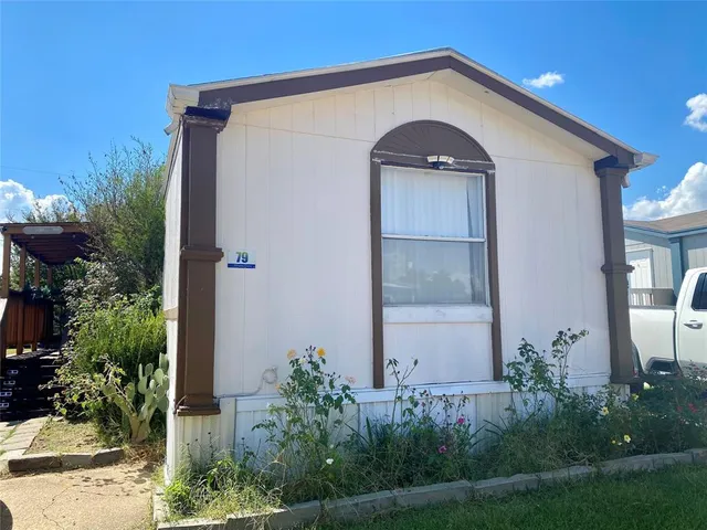 a view of a small house with potted plants